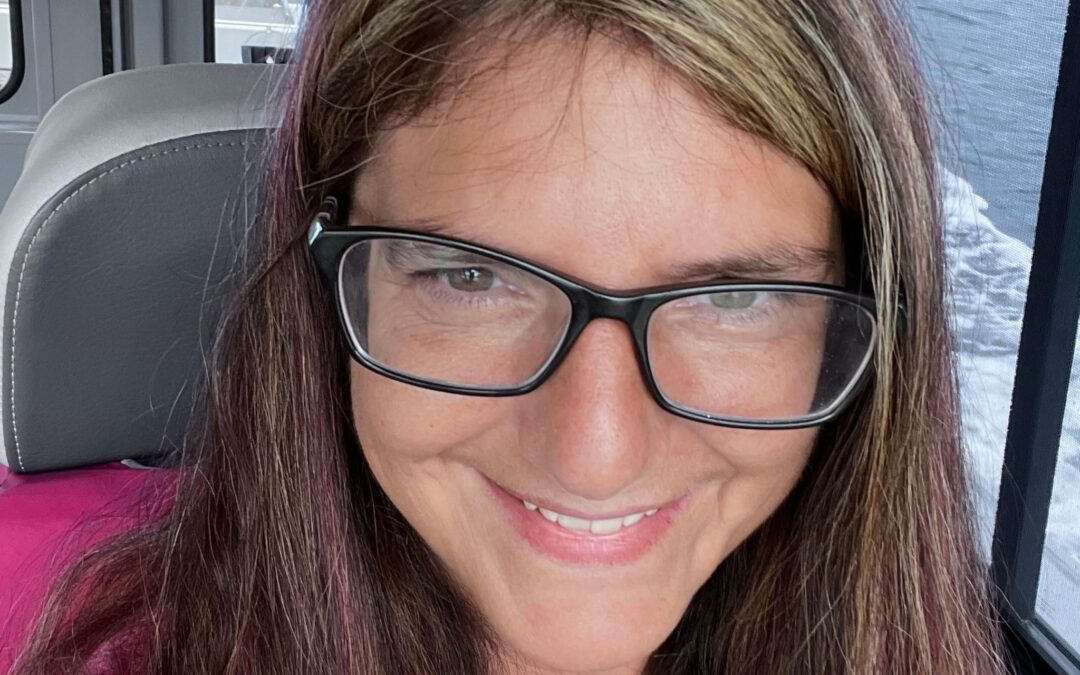board member Danielle Lindoff, who wears glasses and is sitting in the cabin of a small skiff